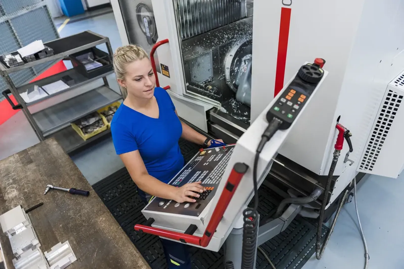 Operator working at an industrial control panel on a factory floor