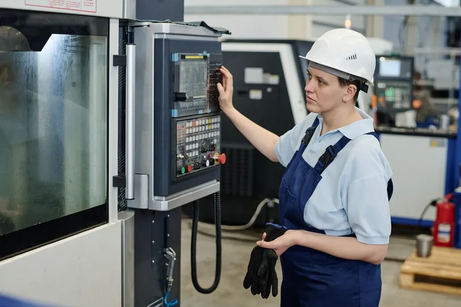 Young worker operating a CNC machine
